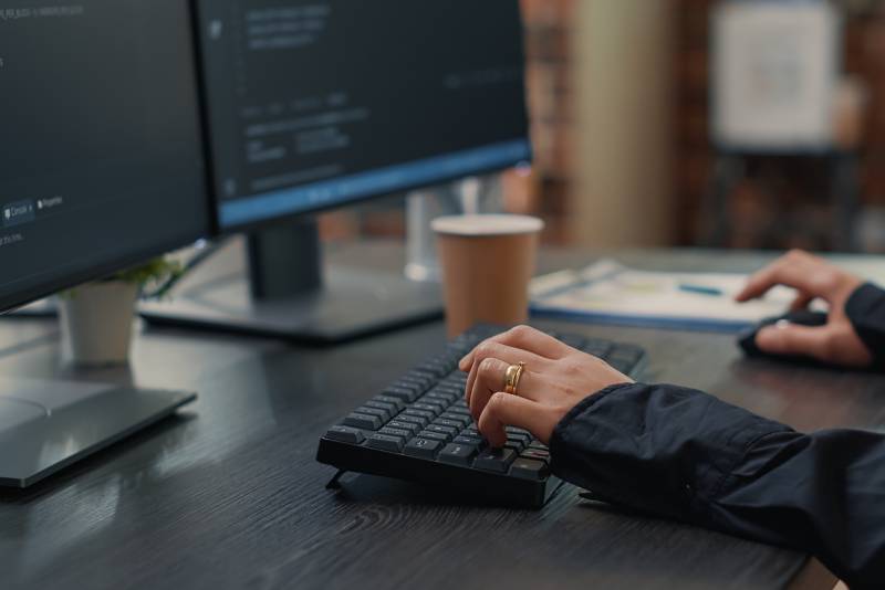 Homme travaillant en cyber sécurité sur son clavier d'ordinateur