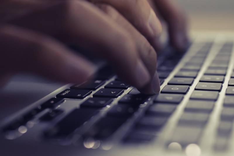 Homme tapant sur un clavier d'ordinateur